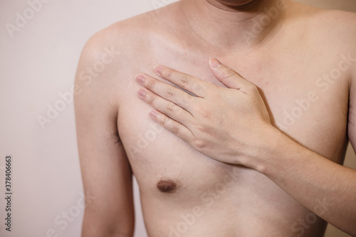 Chest Pain Young man holding hand to chest pain.