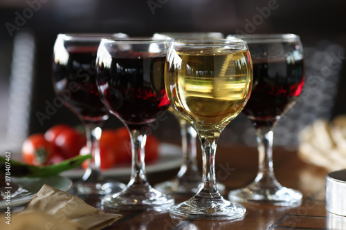 Four glasses of wine are on festive table. Professional table setting. Reserving table in cafe.