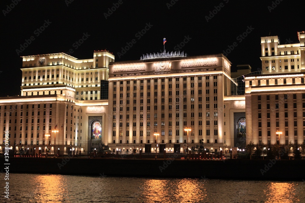 Colorful panorama of the night city with neon lights. Main building of the Ministry of Defense of Russia