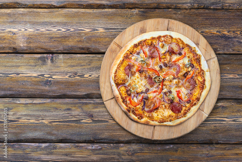 cutting board with hot testy pizza on wooden background,top view 