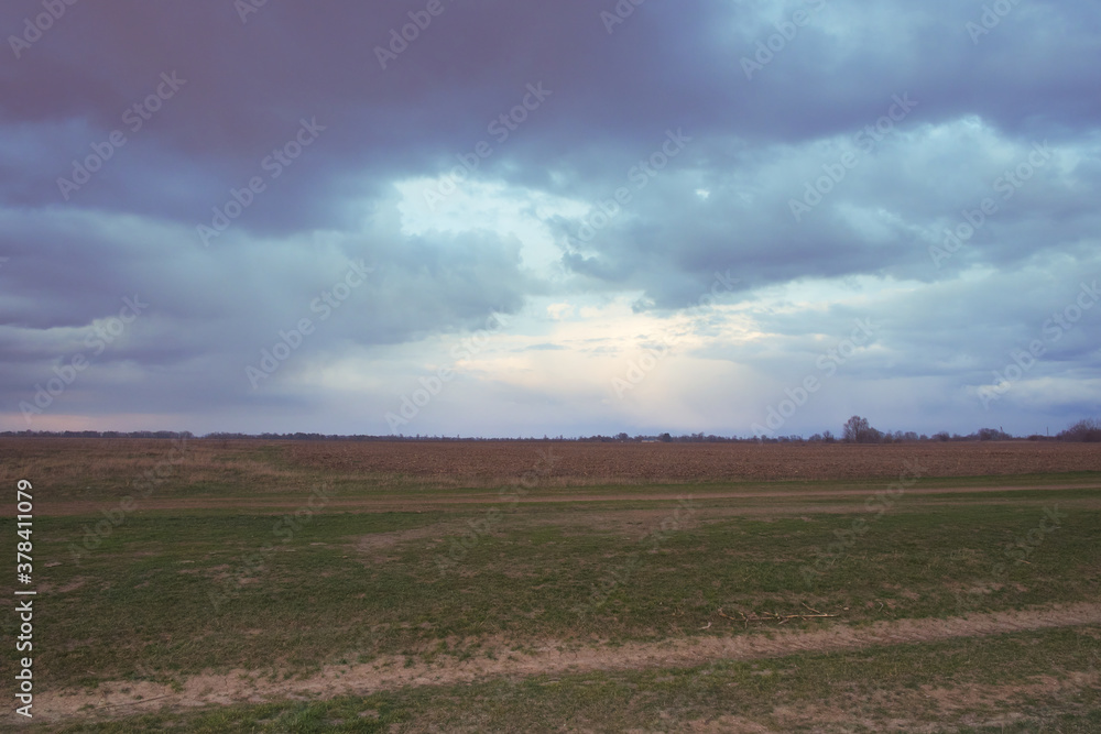 Dramatic pre-storm sky over the field. Spring landscape.