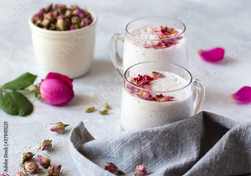 Pink moon milk with rose petals, healthy ayurvedic drink in glass mug