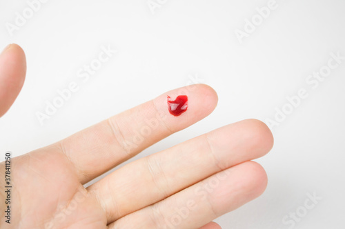 fresh cut with a drop of blood on the finger