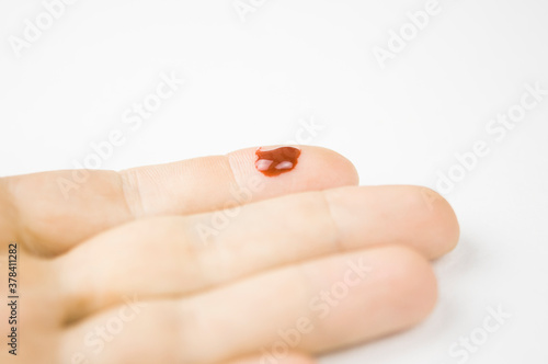 fresh cut with a drop of blood on the finger