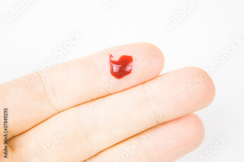 fresh cut with a drop of blood on the finger
