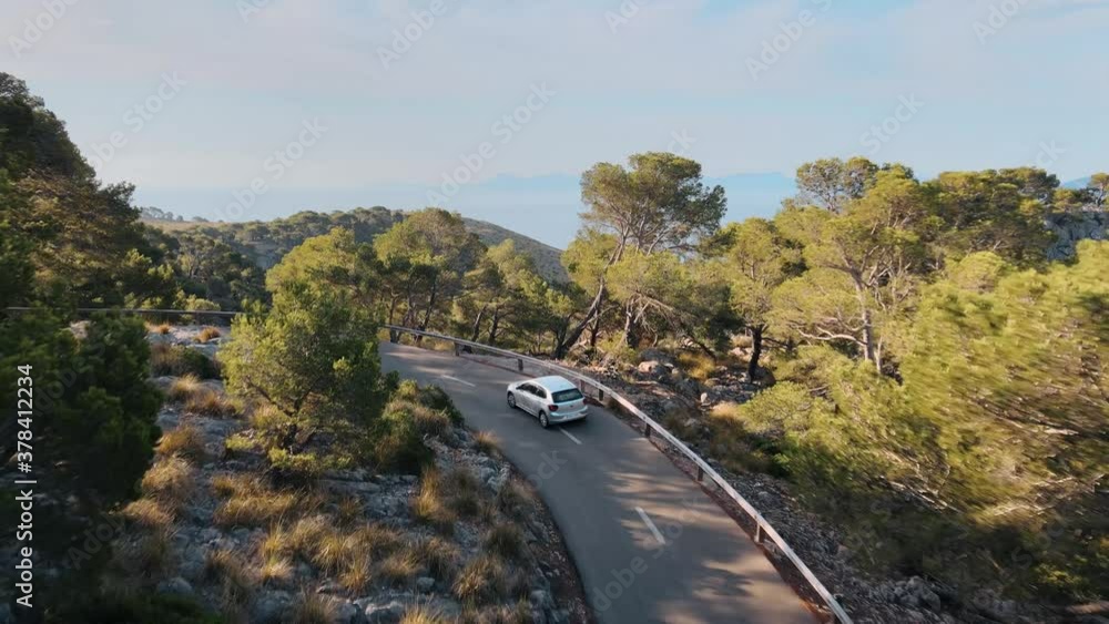 Aerial view of a car driving on a mountain road and revealing the stunning landscape with sea on background Aerial view of a car driving on a mountain road and revealing the stunning landscape with sea on background