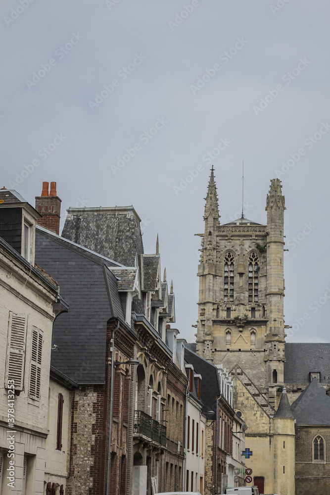 Fototapeta premium Built in heart of Fecamp XVI century Saint-Etienne church dominates now wearing Norman city: Renaissance portal, flamboyant Gothic steeple. Fecamp, Seine-Maritime department, Haute-Normandie, France.