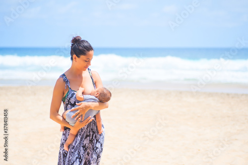 Frau stillt Baby am Strand