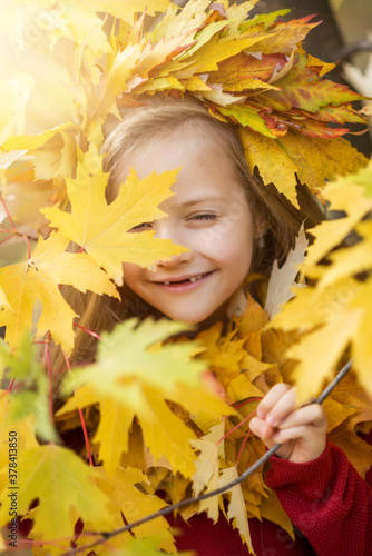 funny girl child in yellow autumn leaves