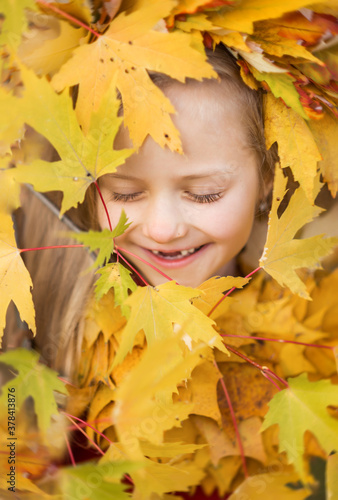 funny girl child in yellow autumn leaves