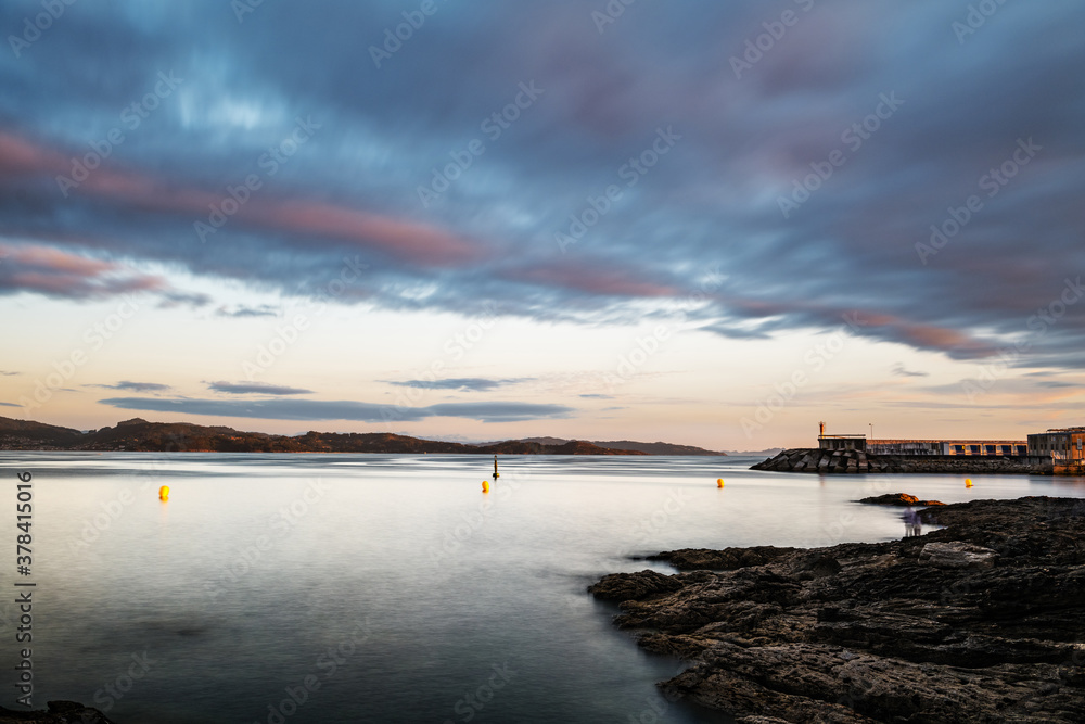 Rocks and small lighthouse on a calm cloudy evening in the Rias Baixas in Galicia, Spain. Long exposure. Rocks and small lighthouse on a calm cloudy evening in the Rias Baixas in Galicia, Spain. Long exposure.