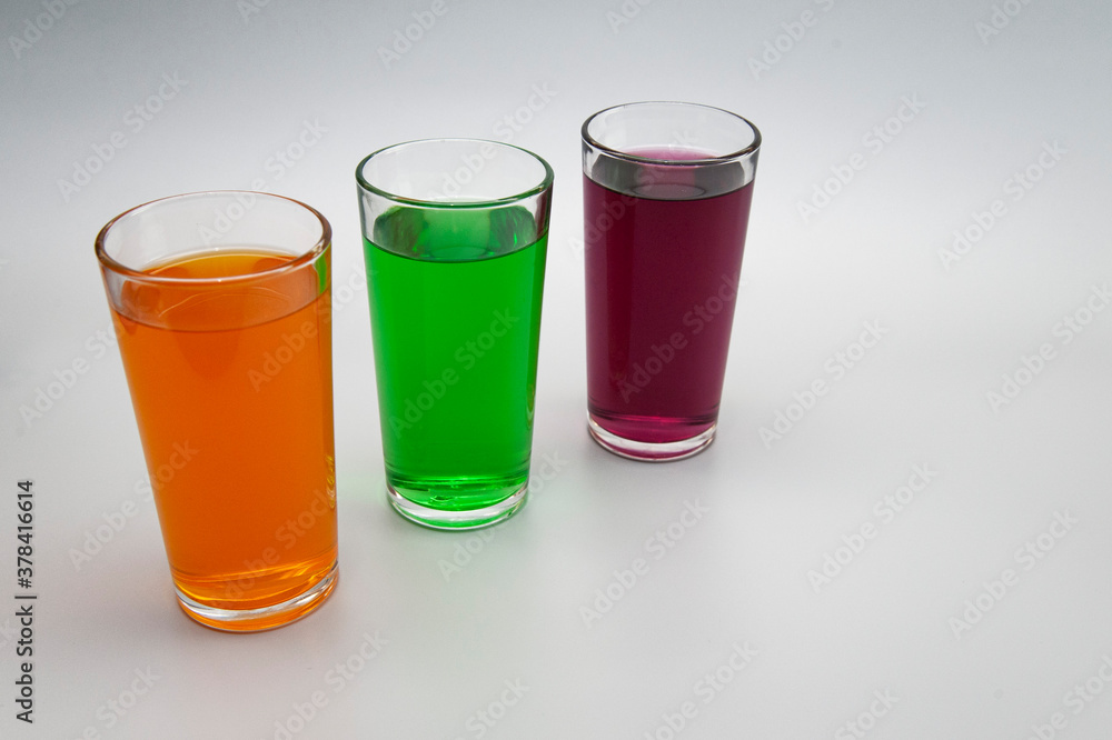 three glasses with different juices on a white background three glasses with different juices on a white background