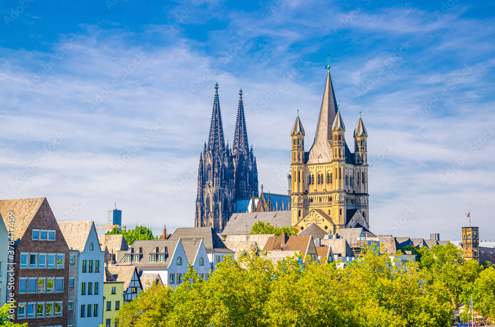 View of historical city centre with towers of Cologne Cathedral of Saint Peter, Great Saint Martin Roman Catholic Church buildings and roofs of colorful houses, North Rhine-Westphalia, Germany