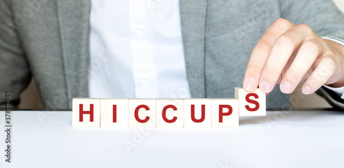 Word HICCUPS made with wood building blocks photo