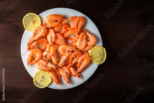 shrimp on a plate with lemons on a wooden table