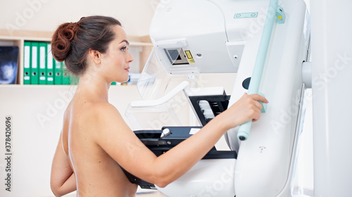 Healthy young woman doing cancer prophylactic mammography scan at hospital.