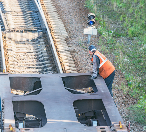 Railway worker stands on the freight railway carriage.