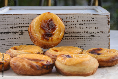 Фотография Traditional Portuguese popular dessert Pastel de nata or Pastel de Belem on a white wooden board
