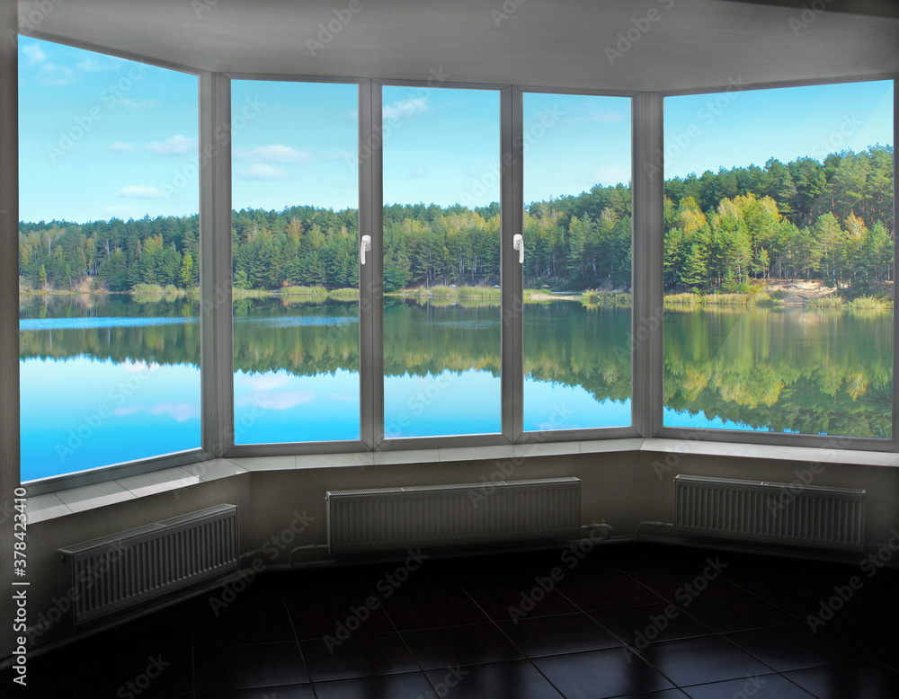 Room with big window in room with panoramic view to forest lake