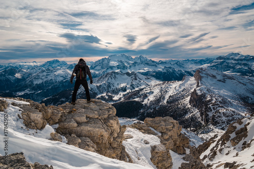 hiking explorer on top of mountain looking for direction in front of dolomites landscape in Cortina surroundings, holiday destination. Beautiful place icon, iconic mountain panorama © Michele Milanese
