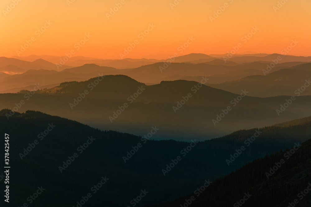 Fog or haze at sunrise in the Carpathians, Ukrainian Pip Ivan and sunrise near Montenegro, picturesque mountain landscapes.