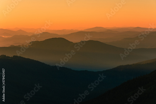 Fog or haze at sunrise in the Carpathians, Ukrainian Pip Ivan and sunrise near Montenegro, picturesque mountain landscapes.