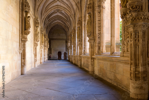 Gothic Cloister - A wide-angle view of evening sunlight shining in lower cloister of the 15th-century Isabelline Gothic style church Monastery of Saint John of the Monarchs, Toledo, Spain.
