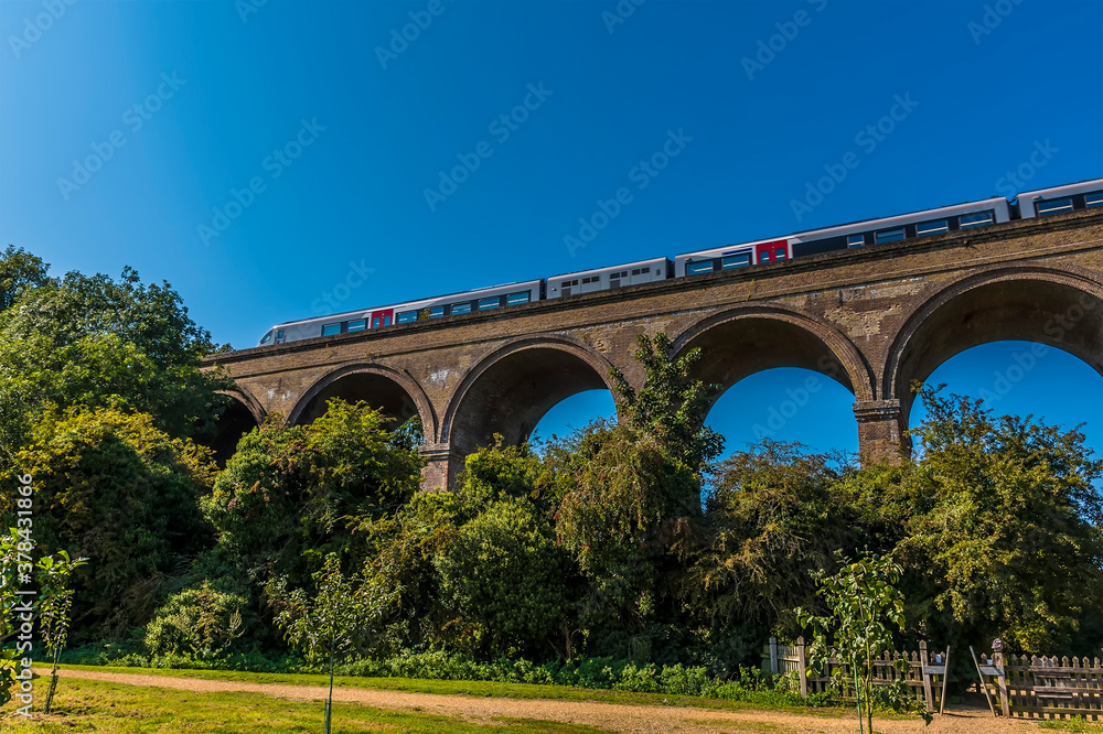 A train crosses a section of the Chappel Viaduct near Colchester, UK in the summertime A train crosses a section of the Chappel Viaduct near Colchester, UK in the summertime