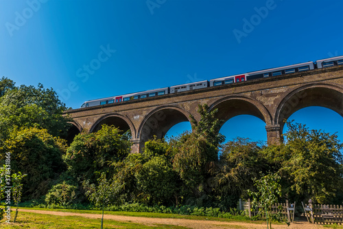A train crosses a section of the Chappel Viaduct near Colchester, UK in the summertime photo