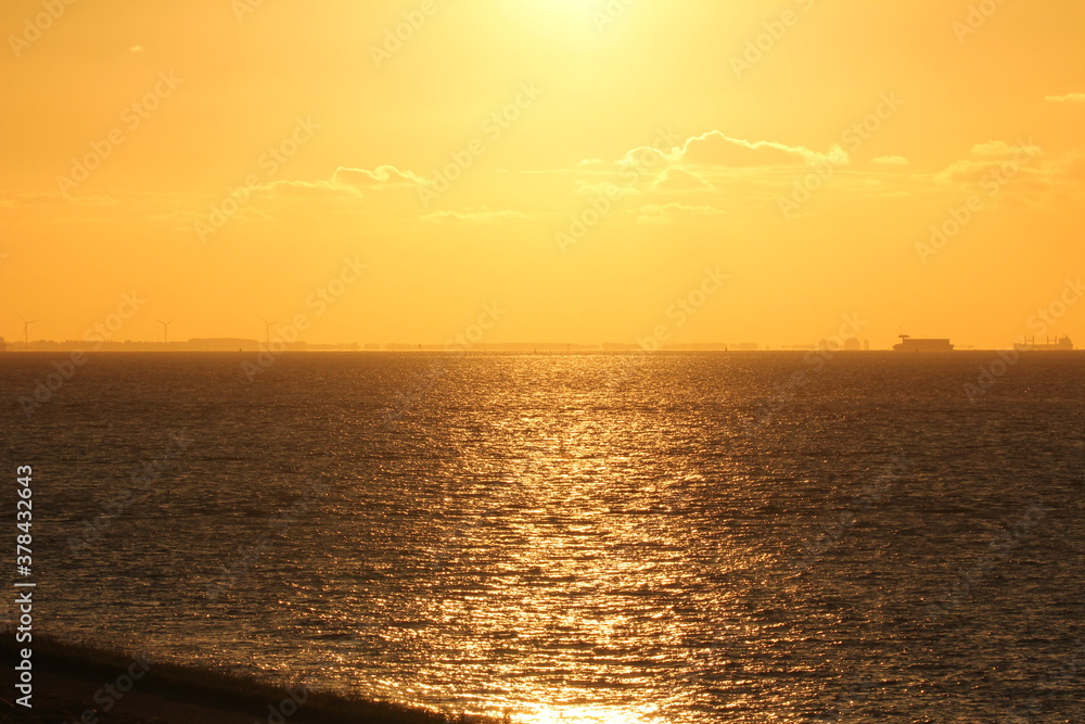 Fototapeta premium an orange sky during sunset in summer above a black sea