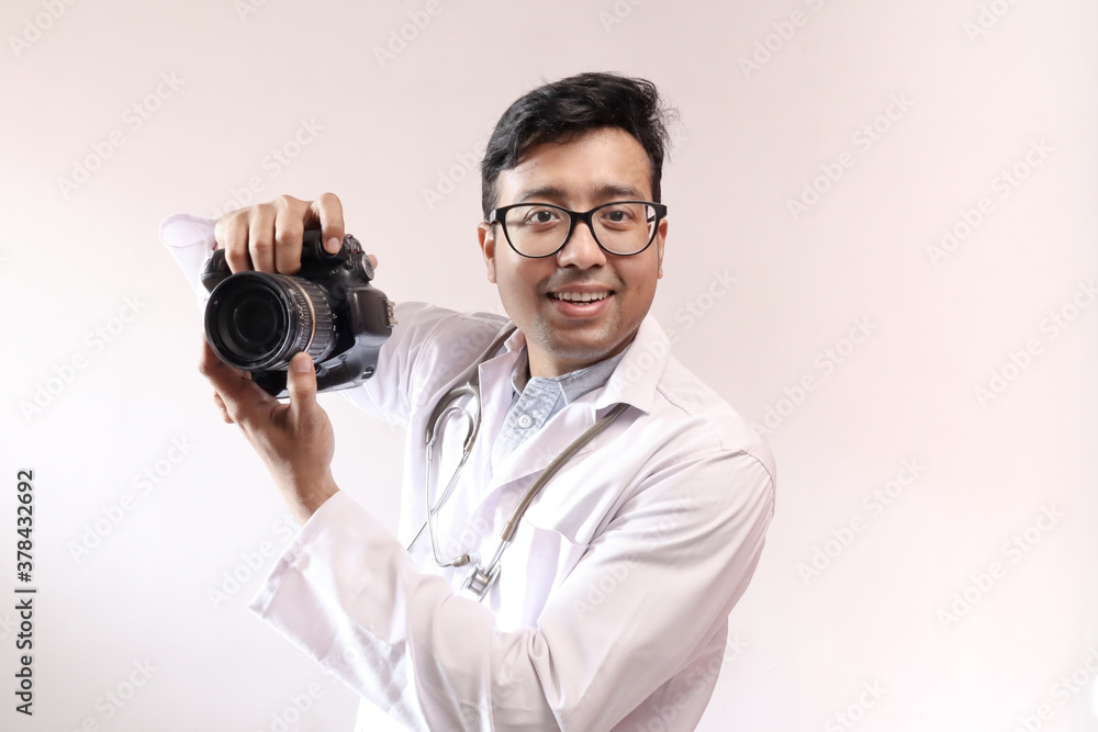 male indian doctor in white coat and stethoscope and a DSLR camera in hand, doctor as a photographer male indian doctor in white coat and stethoscope and a DSLR camera in hand, doctor as a photographer