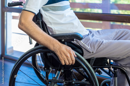 Close up of a disabled man in a wheelchair near the window