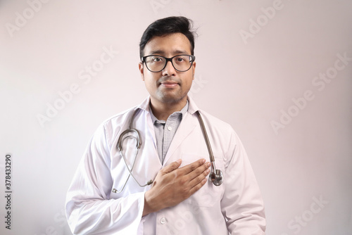 male indian doctor in white coat and stethoscope swearing hippocratic oath photo