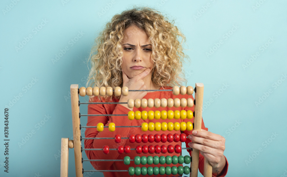 Obraz premium Girl with abacus is confused about the sum . cyan background