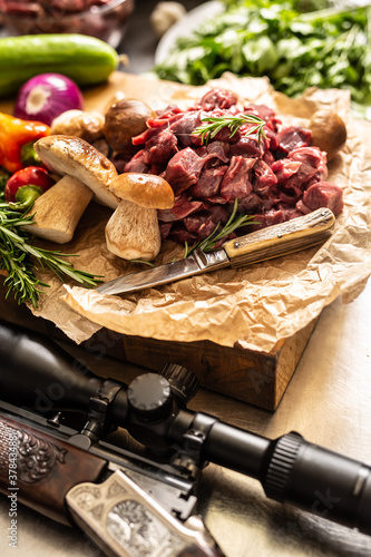 Konstfotografi Sliced deer meat prepared for stew of game forest mushrooms herbs vegetables kni