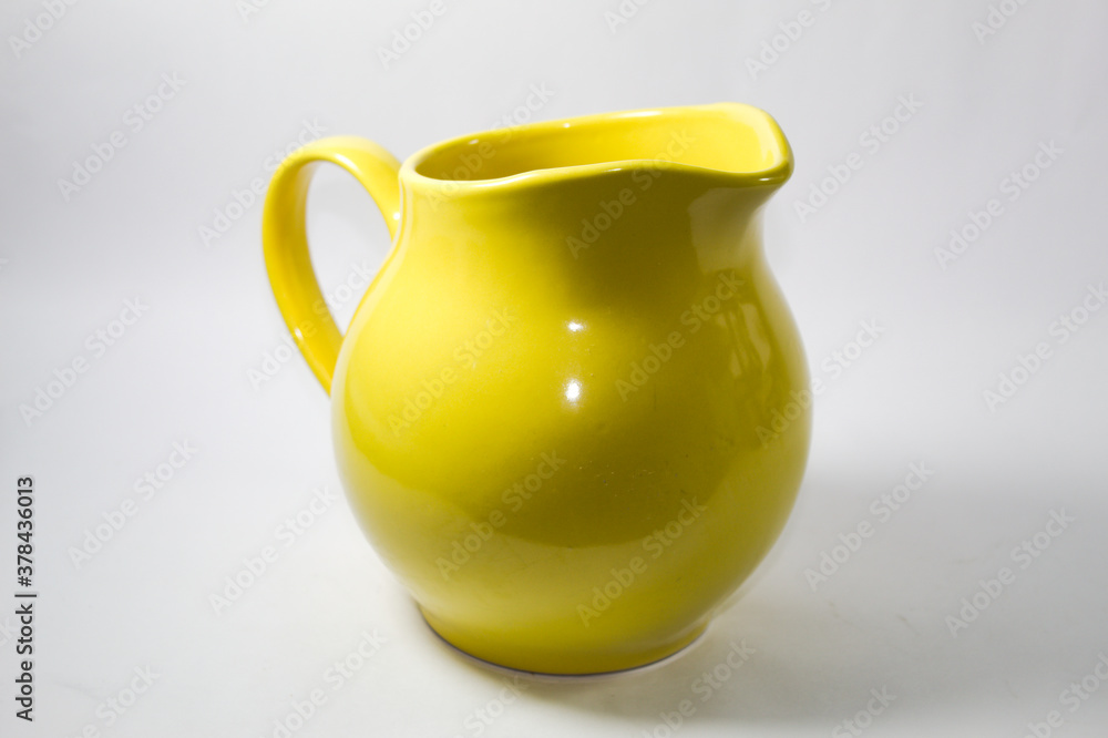 Yellow ceramic milk jug on a white background
