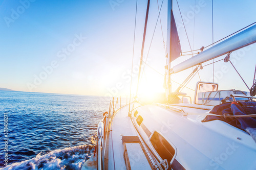 Fototapeta Naklejka Na Ścianę i Meble -  Yacht Sailing against sunset. Sailboat. Travel Concept
