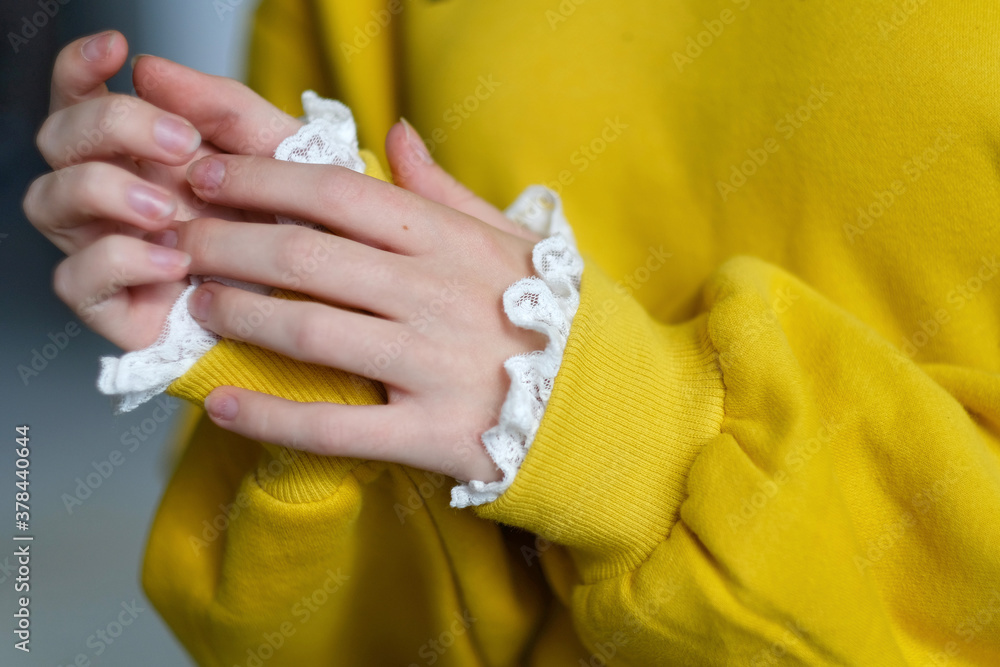 Fototapeta premium details of sleeves of fashionable yellow sweatshirt on model.