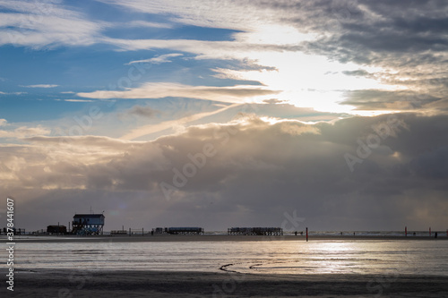 Panoramic view of stilt houses and wooden seabridge at north sea beach in Sankt Peter-Ording, Germany. © A. Emson