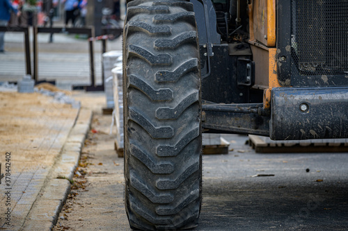 front wheel of a wheeled tractor standing on the road. Street renovation.