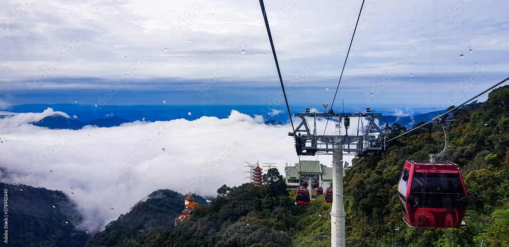 cable car at genting highlands, malaysia in a foggy weather with green grass visible from inside cable car