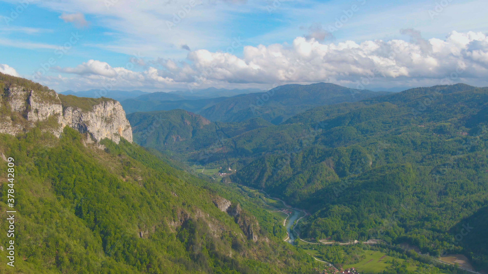 AERIAL: Flying over a spectacular forest covered valley in Slovenian countryside