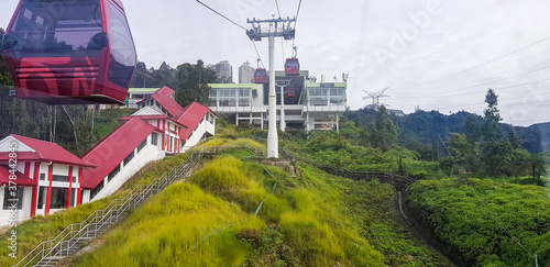 cable car at genting highlands, malaysia in a foggy weather with green grass visible from inside cable car photo