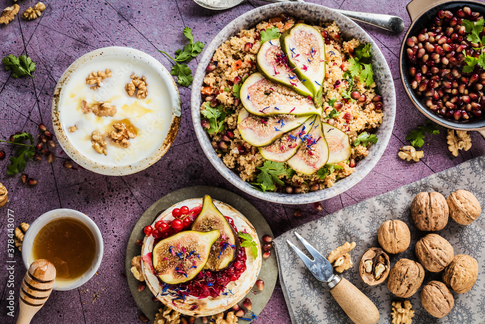 top view of gourmet dish with Figs fruits, nuts, honey, couscous and pomegranate seeds on table top view of gourmet dish with Figs fruits, nuts, honey, couscous and pomegranate seeds on table