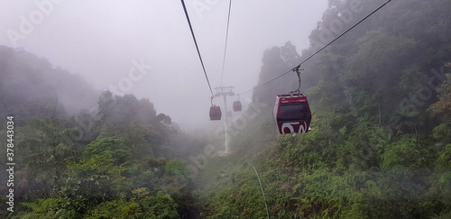 cable car at genting highlands, malaysia in a foggy weather with green grass visible from inside cable car