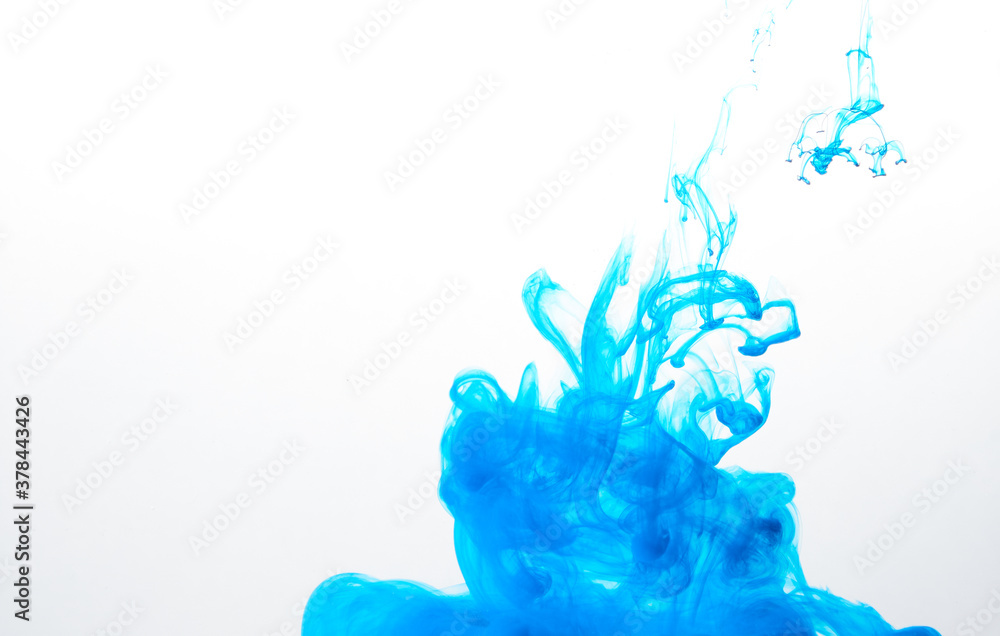 Closeup of a blue ink in water in motion isolated on white. Ink swirling underwater. Colored abstract smoke explosion effect. Abstract background with copy space.. Closeup of a blue ink in water in motion isolated on white. Ink swirling underwater. Colored abstract smoke explosion effect. Abstract background with copy space..