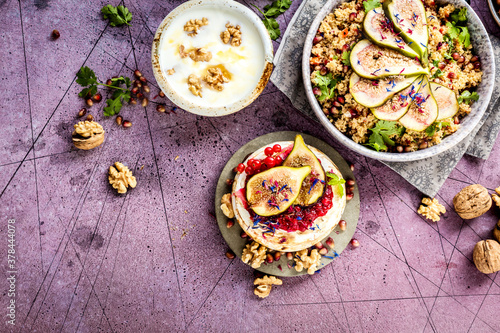 top view of gourmet dish with Figs fruits  nuts  honey  couscous and pomegranate seeds on table