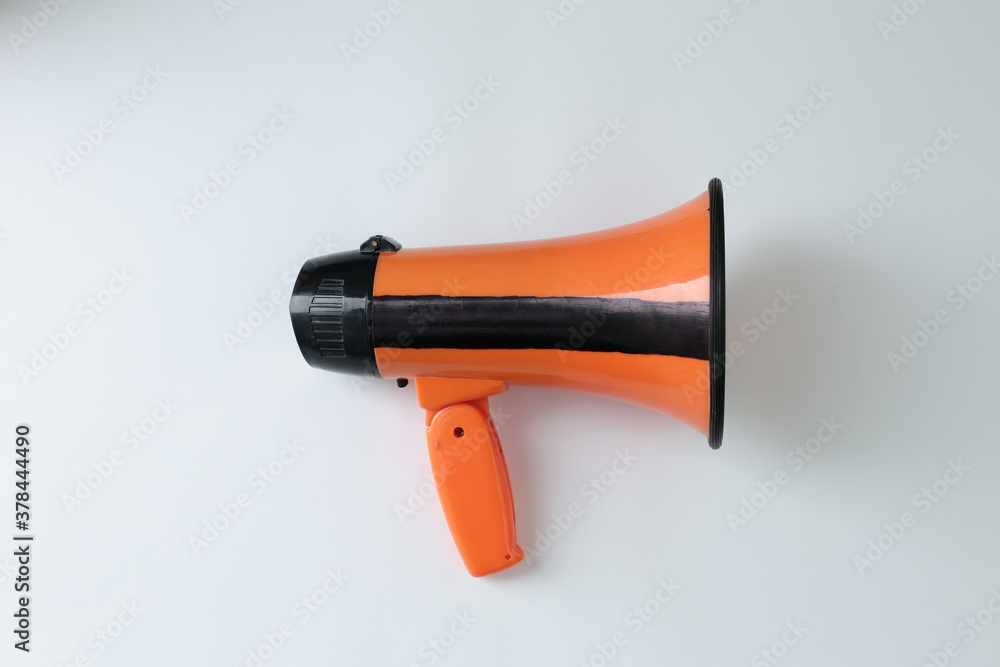 An orange loudspeaker is shown against a white background An orange loudspeaker is shown against a white background