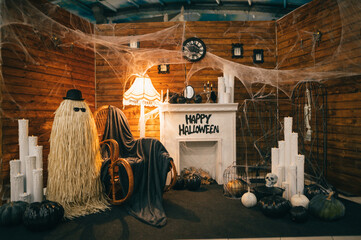 Photo area for Halloween with a fireplace, a chair and objects with Halloween symbols. Halloween decor idea. Background.
