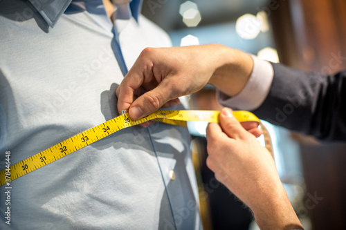 Fotografía Tailor Taking Measurements For A Suit Fitting